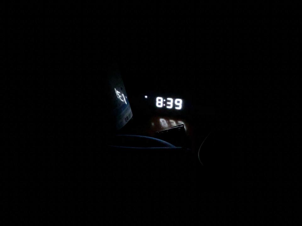 A digital clock that reads 8:39 in a dark room.