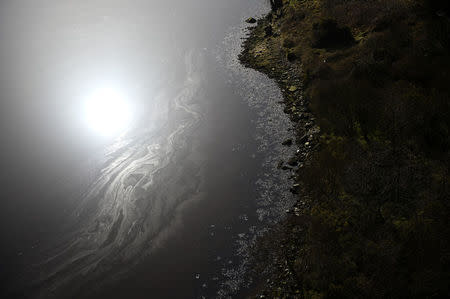 The sun is reflected in Lough Foyle which is part of the Northern Ireland border near Londonderry, Northern Ireland, February 21, 2018. REUTERS/Clodagh Kilcoyne