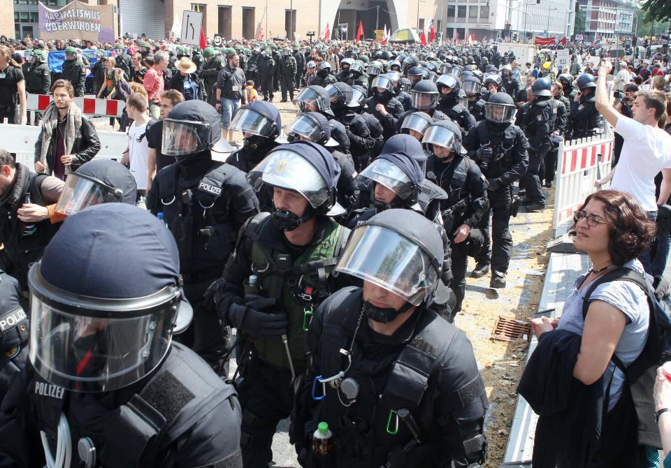 German police officers escort an anti capitalism protest march with some 20,000 people in Frankfurt, Germany, Saturday, May 19, 2012. Protesters peacefully filled the city center of continental Europe's biggest financial hub in their protest against the dominance of banks and what they perceive to be untamed capitalism, Frankfurt police spokesman Ruediger Regis said.  The protest group calling itself Blockupy has called for blocking the access to the European Central Bank, which is located in Frankfurt's business district.  (AP Photo/Michael Probst)