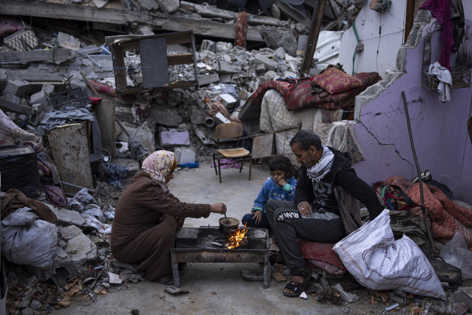 Members of the Al-Rabaya family break their fast during the Muslim holy month of Ramadan outside their destroyed home by the Israeli airstrikes in Rafah, Gaza Strip, Monday, March 18, 2024. (AP Photo/Fatima Shbair)