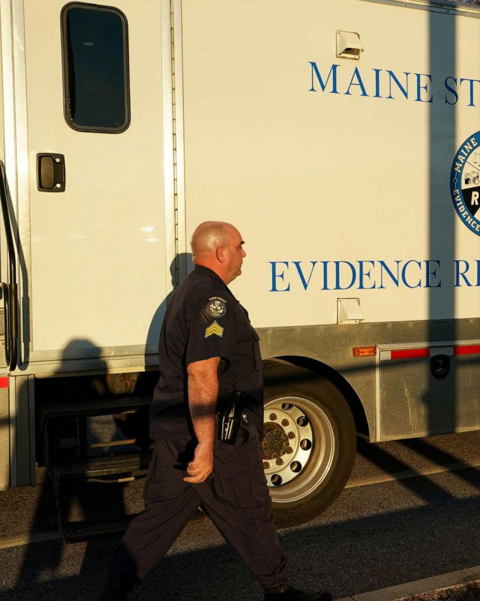 PHOTO: A member of law enforcement walks towards Maine State Police Evidence Response Team vehicle, near the Schemengees Bar & Grille Restaurant, one of the locations of the deadly mass shootings, in Lewiston, Maine, U.S., Oct. 28, 2023. (Kevin Lamarque/Reuters)