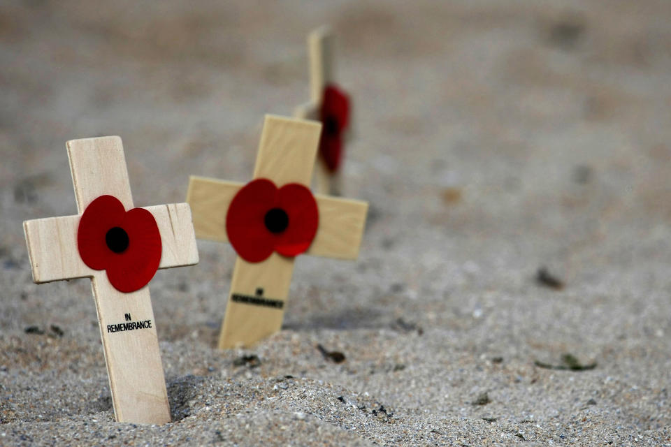 Wooden crosses with poppies are left in (Joel Saget / AFP via Getty Images file)