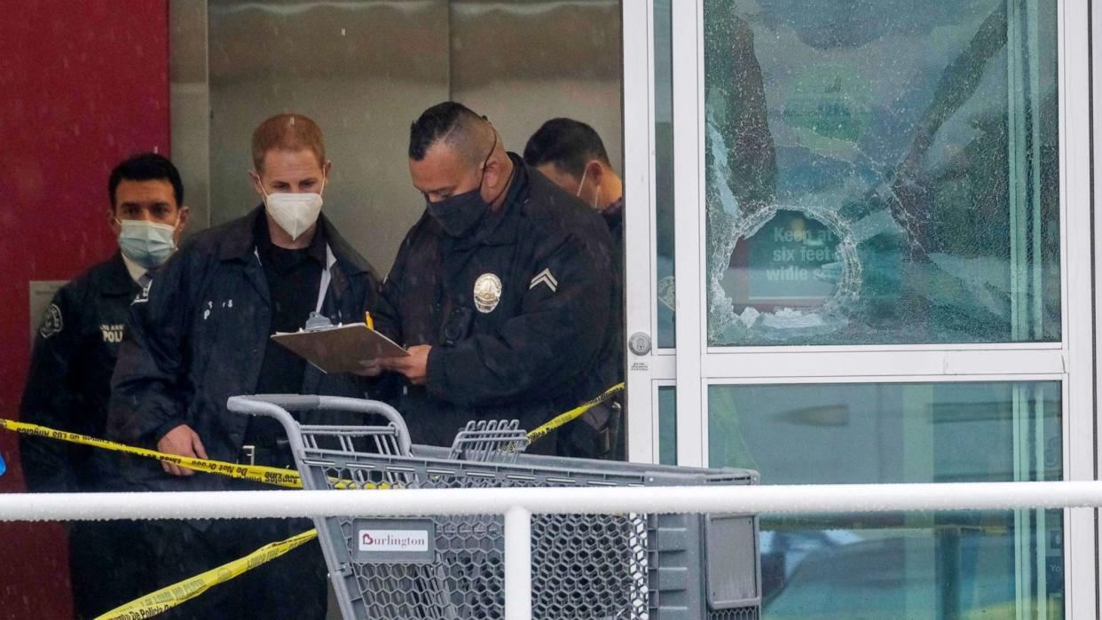 PHOTO: In this Dec. 23, 2021, file photo, police officers work near a broken glass door at the scene where two people were struck by gunfire in a shooting at the Burlington Coat Factory store in North Hollywood, Calif. (Ringo H.W. Chiu/AP, FILE)