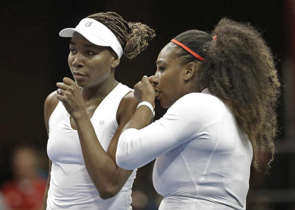 FILE - In this Sunday, Feb. 11, 2018, file photo, USA's Venus Williams, left, and Serena Williams, right, talk between points in their doubles match against Netherlands' Leslie Herkhove and Demi Schuurs in the first round of Fed Cup tennis competition in Asheville, N.C. The siblings meet each other for the 31st time when they take the court at a WTA tournament in Kentucky on Thursday, Aug. 13, 2020. (AP Photo/Chuck Burton, File)