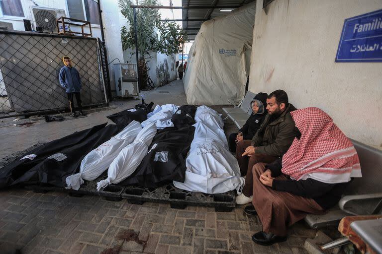 Palestinos en el Hospital al-Najjar de Rafah, junto a los restos de víctimas de los ataques israelíes. Photo: Mohammed Talatene/dpa