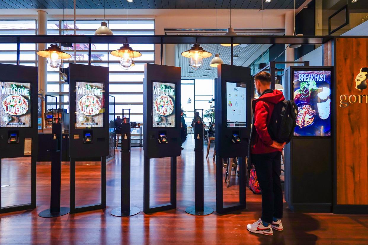 Copenhagen, Denmark Feb 22, 2023 A man orders food from display screens at a restaurant,.