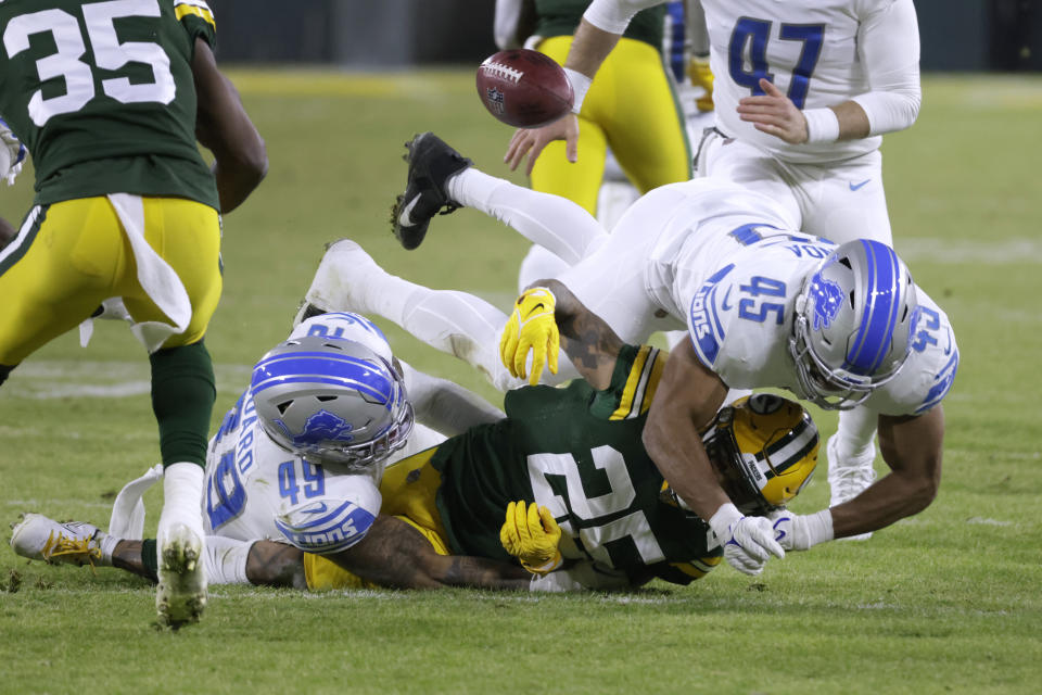 Green Bay Packers' Keisean Nixon (25) fumbles as Detroit Lions' Chris Board (49) and Jason Cabinda (45) defend during the second half of an NFL football game Sunday, Jan. 8, 2023, in Green Bay, Wis. (AP Photo/Mike Roemer)