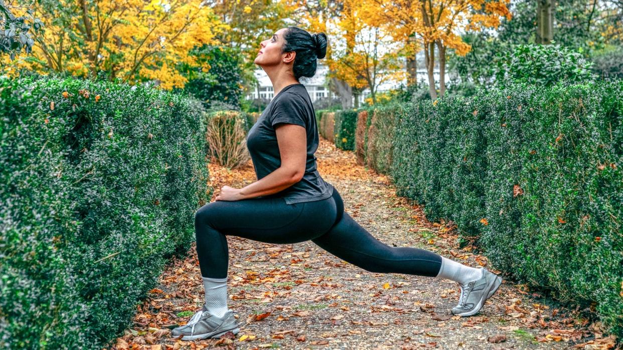  Woman stretching into a forward lunge. 