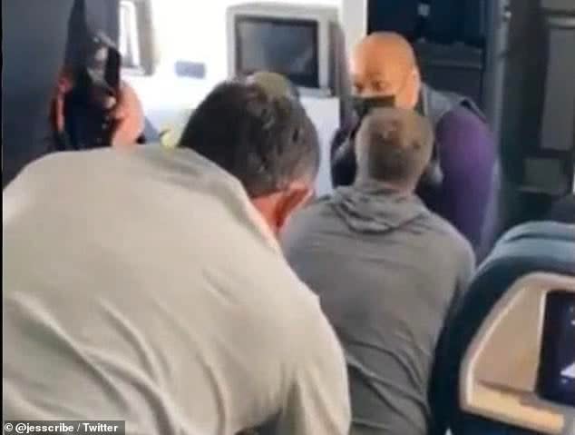 <p>A video posted on Twitter by a passenger on a flight to Nashville shows attendants and passengers holding down a man who reportedly attempted to break into the cockpit</p> (Twitter/Jessica Robertson)