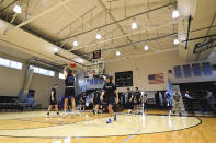 Yeshiva University players warm up in a mostly empty Goldfarb Gymnasium at Johns Hopkins University before playing against Worcester Polytechnic Institute in a first-round game at the men's Division III NCAA college basketball tournament, Friday, March 6, 2020, in Baltimore, The university held the tournament without spectators after cases of COVID-19 were confirmed in Maryland. (AP Photo/Terrance Williams)