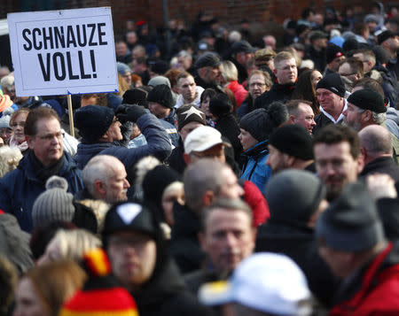 People attend a demonstration against migrants in Cottbus, Germany February 3, 2018. Sign reads "Fed up!". REUTERS/Hannibal Hanschke