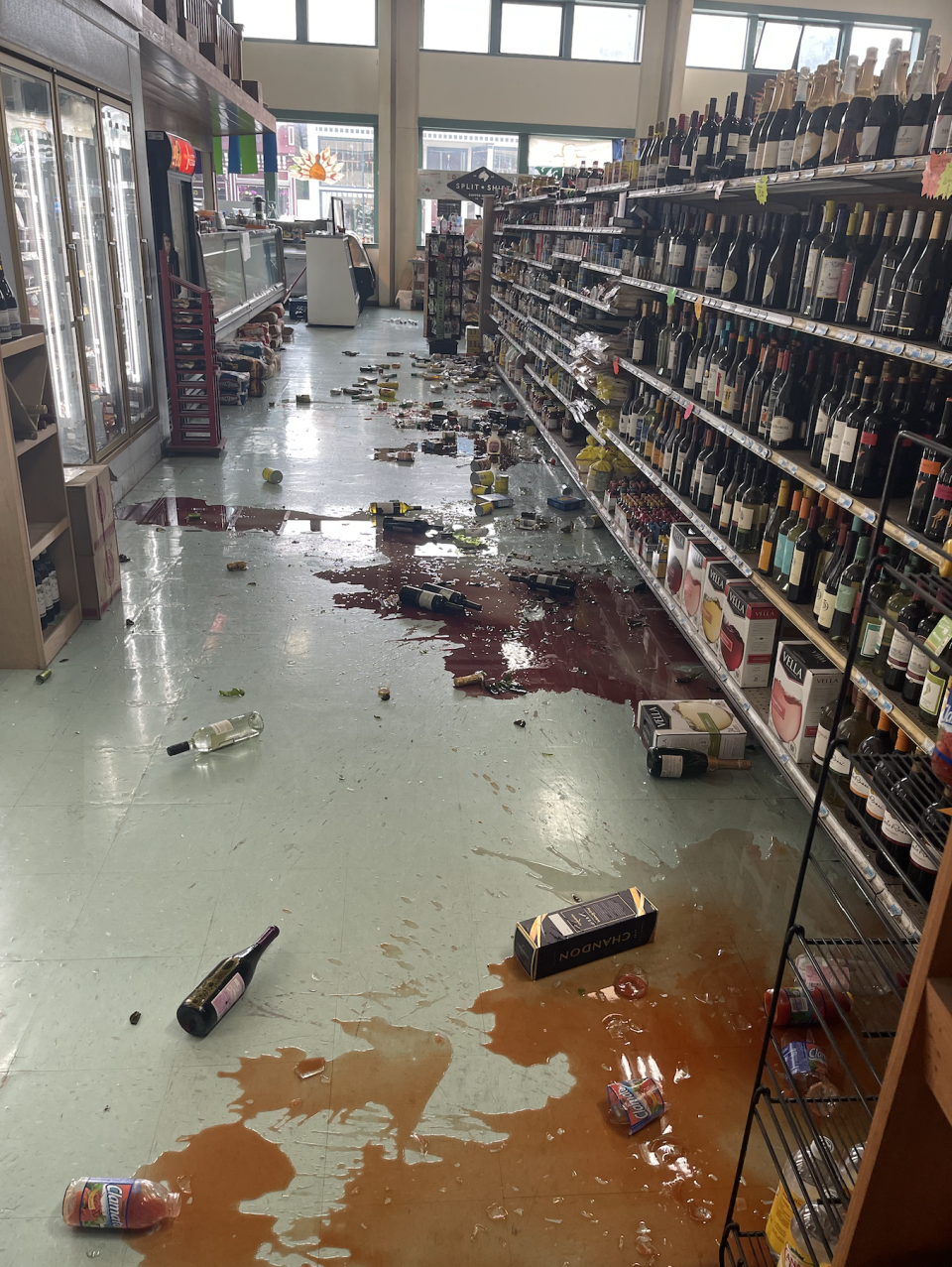 Shaking and trembling from an earthquake in California causes bottles to smash in a local grocery store