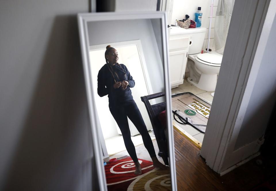 Graham stands in front of a floor-length mirror.