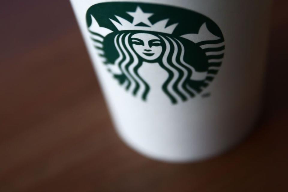 green starbucks coffee logo is seen on a white to go cup