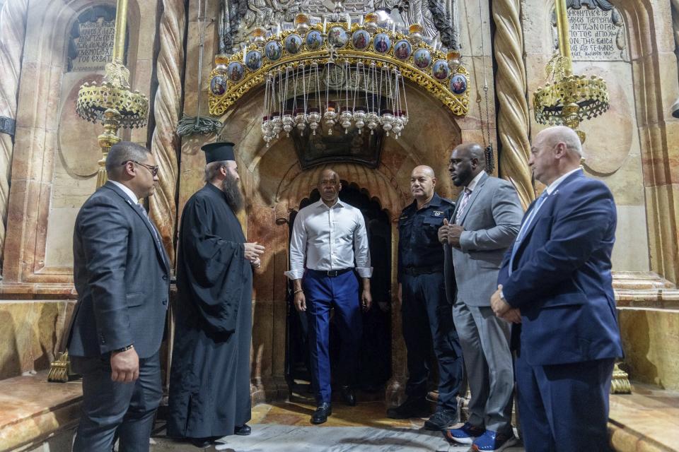 Mayor Eric Adams of New York, center, visits the Church of the Holy Sepulcher in Jerusalem, Tuesday, Aug. 22, 2023. Adams spent the second day of his visit to Israel touring holy sites before a planned meeting with Prime Minister Benjamin Netanyahu as he sought to avoid publicly weighing into the political crises plaguing the nation. (AP Photo/Ohad Zwigenberg)