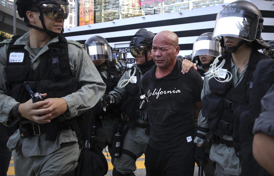 Police officers in riot gear detain a man during an anti-government protest in Hong Kong, Saturday, Nov. 2, 2019. Defying a police ban, thousands of black-clad masked protesters are streaming into Hong Kong's central shopping district for another rally demanding autonomy in the Chinese territory as Beijing indicated it could tighten its grip. (AP Photo/Kin Cheung)