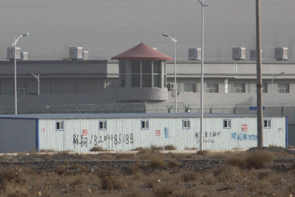 FILE - In this Monday, Dec. 3, 2018, file photo, a guard tower and barbed wire fences are seen around a facility in the Kunshan Industrial Park in Artux in western China's Xinjiang region. China has responded with swift condemnation on Wednesday, Dec. 4, 2019, after U.S. Congress overwhelmingly approved a bill targeting its mass crackdown on ethnic Muslim minorities. (AP Photo/Ng Han Guan, File)