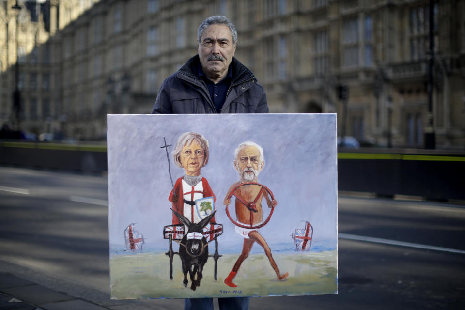 Remain in the European Union supporter Kaya Mar, aged 63 from London and originally from Spain, poses for photographs with one of his paintings that was so new the paint wasn't dry, outside the Houses of Parliament in London, Thursday, Feb. 14, 2019. Kaya believes Brexit is economic suicide and a leave deal that keeps free movement and the economy as it is would be the best way forward. The colorful debate over Britain's Brexit split with the European Union has spilled over from Parliament to the grounds outside, traditionally a marketplace for ideas, protests and rallies.(AP Photo/Matt Dunham)