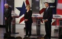 Democratic U.S. presidential candidates Senator Bernie Sanders (L), former Secretary of State Hillary Clinton and former Maryland Governor Martin O'Malley bow their heads in a moment of silence for the recent attacks in Paris ahead of the second official 2016 U.S. Democratic presidential candidates debate in Des Moines, Iowa, November 14, 2015. REUTERS/Jim Young