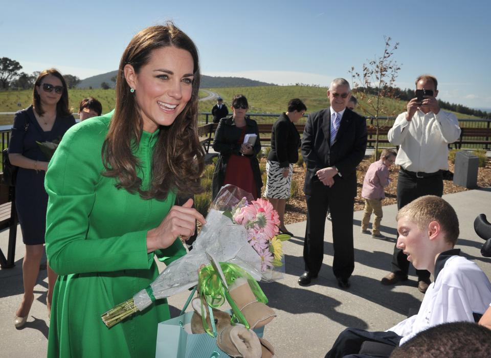 Britain's Catherine, Duchess of Cambridge (L), receives gifts for her son Prince George while visiting the National Arboretum in Canberra on April 24, 2014. Britain's Prince William, his wife Kate and their son Prince George are on a three-week tour of New Zealand and Australia.    AFP PHOTO / Mark GRAHAM        (Photo credit should read MARK GRAHAM/AFP via Getty Images)