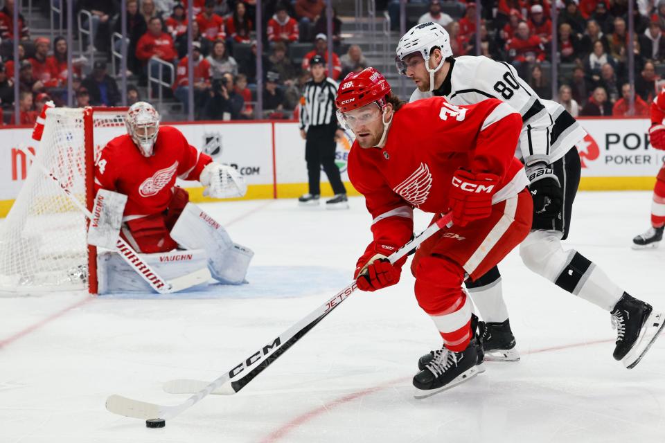 Red Wings right wing Christian Fischer skates with the puck chased by Kings center Pierre-Luc Dubois in the first period on Saturday, Jan. 13, 2024, at Little Caesars Arena.