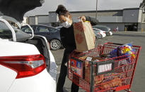 FILE - In this July 1, 2020 file photo, Instacart worker Saori Okawa loads groceries into her car for home delivery in San Leandro, Calif. A battle between the powerhouses of the so-called gig economy and big labor could become the most expensive ballot measure in California history. Voters are being asked to decide via Proposition 22 whether to create an exemption to a new state law aimed at providing wage and benefit protections to Uber, Lyft and other app-based drivers.Okawa, who drove 10 hours a day, six days a week for Uber for a year in San Francisco and now delivers food, said she's opposed to the ballot measure because she wants more protections for drivers, many of whom are immigrants like her. (AP Photo/Ben Margot, File)
