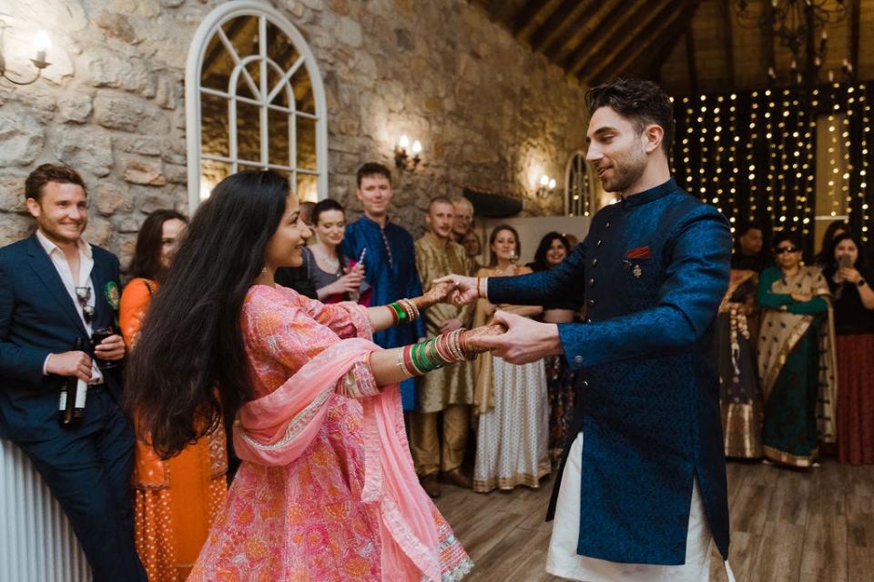 Alastair Spray and Angie Tiwari dancing during their Scottish-Indian wedding.