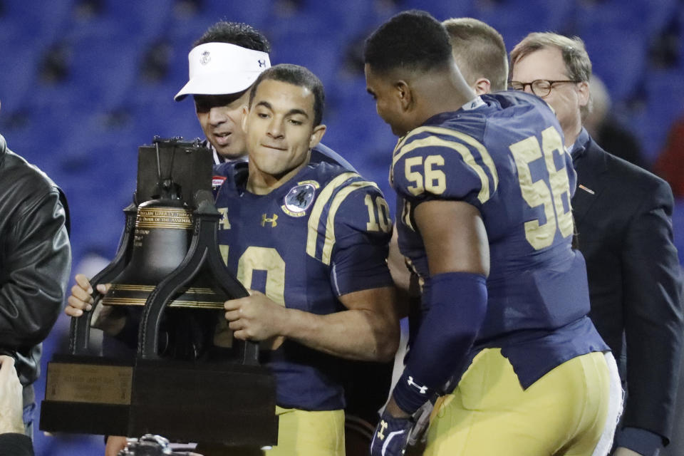 Navy quarterback Malcolm Perry (10) holds the trophy after Navy beat Kansas State in the Liberty Bowl NCAA college football game Tuesday, Dec. 31, 2019, in Memphis, Tenn. Navy won 20-17. (AP Photo/Mark Humphrey)