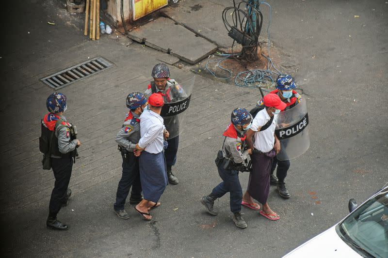 Anti-coup demonstrators are detained by police officers during a protest against the military coup in Yangon