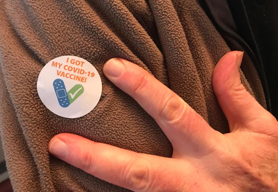 A Vermonter displays his COVID-19 vaccination sticker at the DoubleTree by Hilton in South Burlington on March 4.