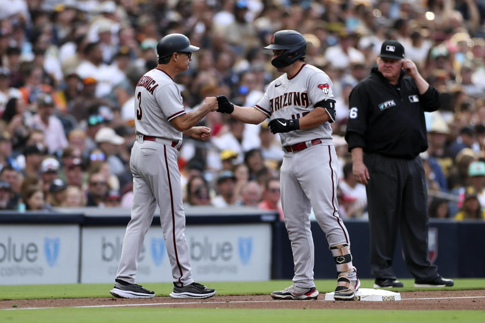 Arizona Diamondbacks' Buddy Kennedy, right, is congratulated by third base coach Tony Perezchica after hitting an RBI triple against the San Diego Padres in the fourth inning of a baseball game, Saturday, July 16, 2022, in San Diego. (AP Photo/Derrick Tuskan)