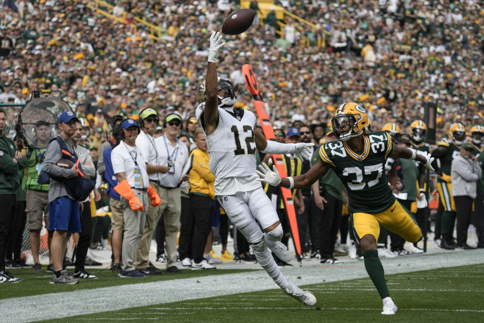 New Orleans Saints wide receiver Chris Olave (12) pulls in a pass over Green Bay Packers cornerback Carrington Valentine (37) during the first half of an NFL football game Sunday, Sept. 24, 2023, in Green Bay, Wis. (AP Photo/Morry Gash)