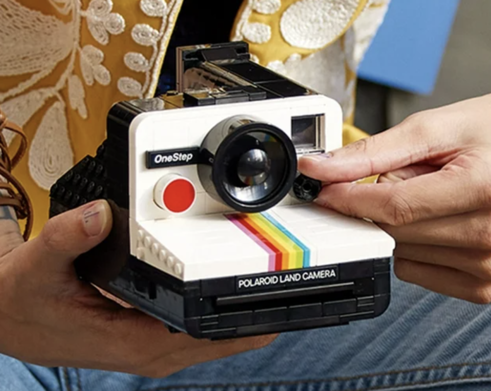 Person holding a vintage-style Polaroid OneStep Land camera, suggesting retro photography shopping.