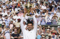 Novak Djokovic alza el trofeo de campeón de Wimbledon tras derrotar a Nick Kyrgios en la final, el domingo 10 de julio de 2022. (AP Foto/Kirsty Wigglesworth)