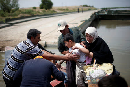 Displaced Iraqis get in a boat to cross the Tigris River after the bridge has been temporarily closed, in western Mosul, Iraq May 6, 2017. REUTERS/Suhaib Salem