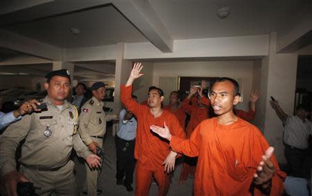 Men convicted of plotting to overthrow the Cambodian government shout as they walk out after being sentenced at the Phnom Penh Municipal Court April 11, 2014. REUTERS/Samrang Pring