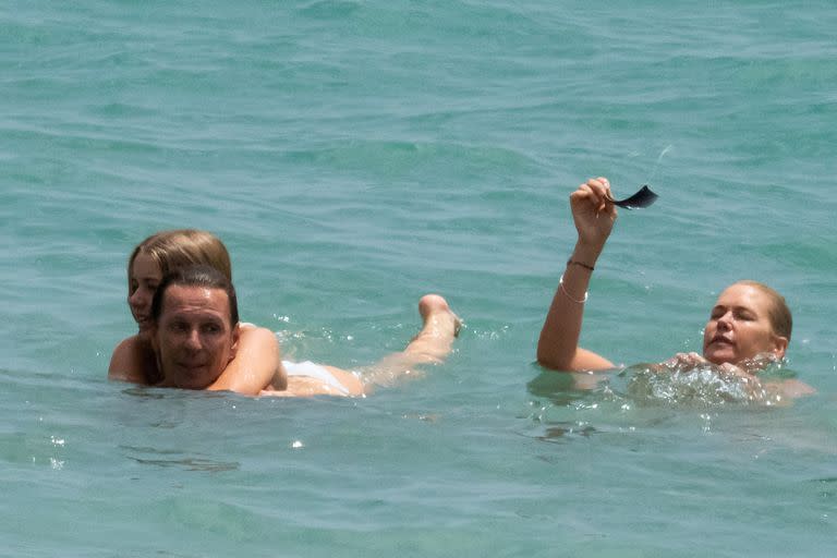 Taína la más pequeña de la familia Mazza-Gravier abrazada a su padre disfruta del mar junto a su mamá Valeria