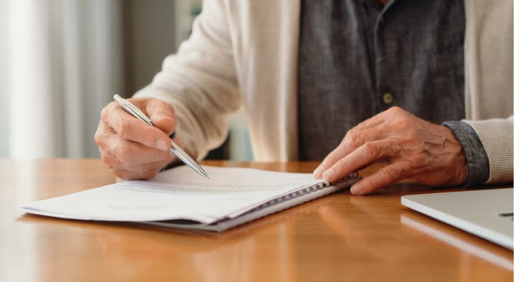 A man signs documents setting up Medicaid asset protection trust. 