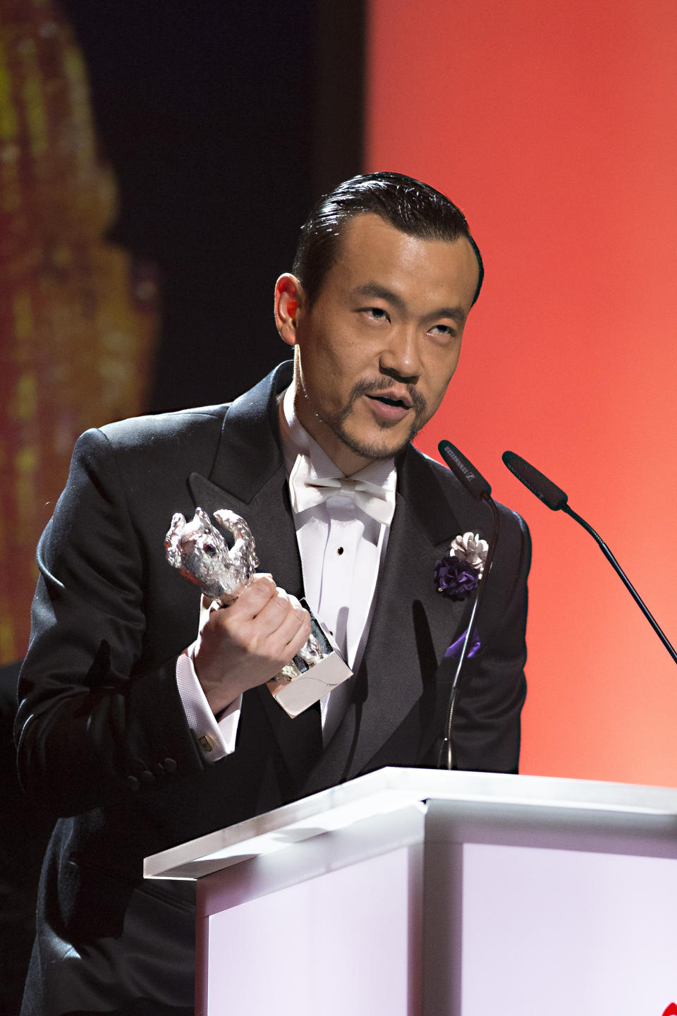 Actor Liao Fan receives the Silver Bear for best actor in the movie Black Coal, Thin Ice during the award ceremony at the International Film Festival Berlinale in Berlin, Saturday, Feb. 15, 2014. (AP Photo/Axel Schmidt)