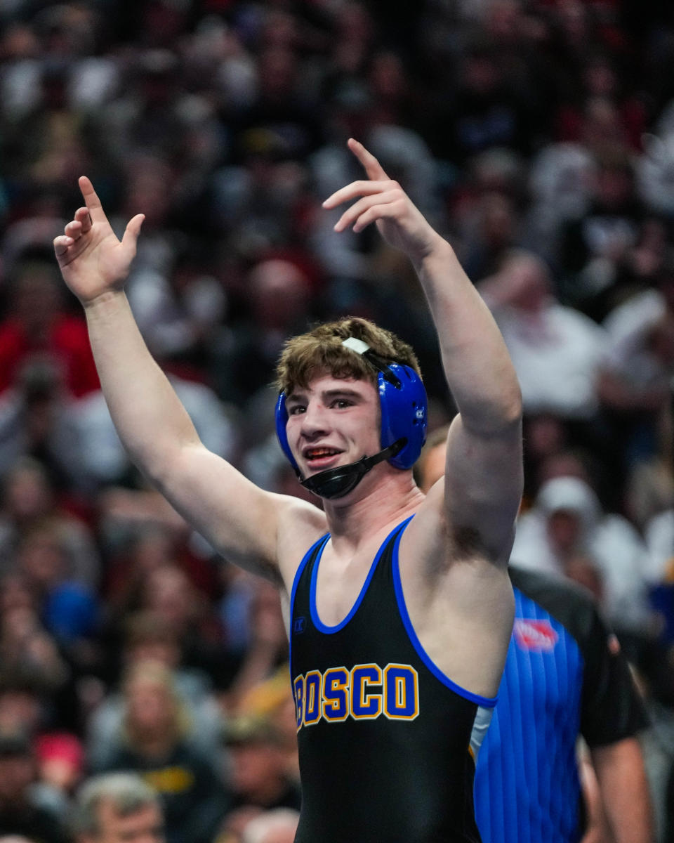 West Hancock's Kellen Smith celebrates his victory over Don Bosco's Kyler Knaack at 152 pounds during the championship round of the Class 1A state wrestling tournament Saturday.