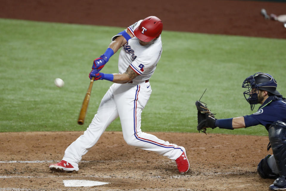 Texas Rangers Derek Dietrich connects for a double as Seattle Mariners catcher Austin Nola looks on in the fourth inning of a baseball game in Arlington, Texas, Wednesday, Aug. 12, 2020. (AP Photo/Tony Gutierrez)