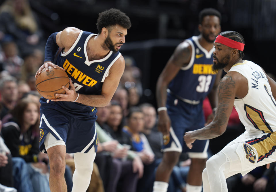 Denver Nuggets guard Jamal Murray, left, looks to drive to the rim as New Orleans Pelicans forward Naji Marshall drops back to defend in the second half of an NBA basketball game Tuesday, Jan. 31, 2023, in Denver. (AP Photo/David Zalubowski)