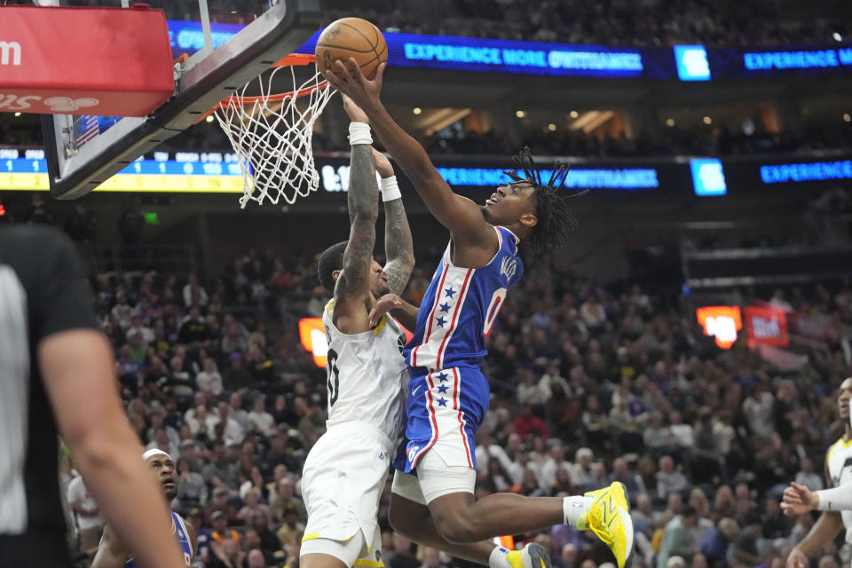 Philadelphia 76ers guard Tyrese Maxey (0) goes to the basket as Utah Jazz forward John Collins, left, defends during the first half of an NBA basketball game Thursday, Feb. 1, 2024, in Salt Lake City. (AP Photo/Rick Bowmer)