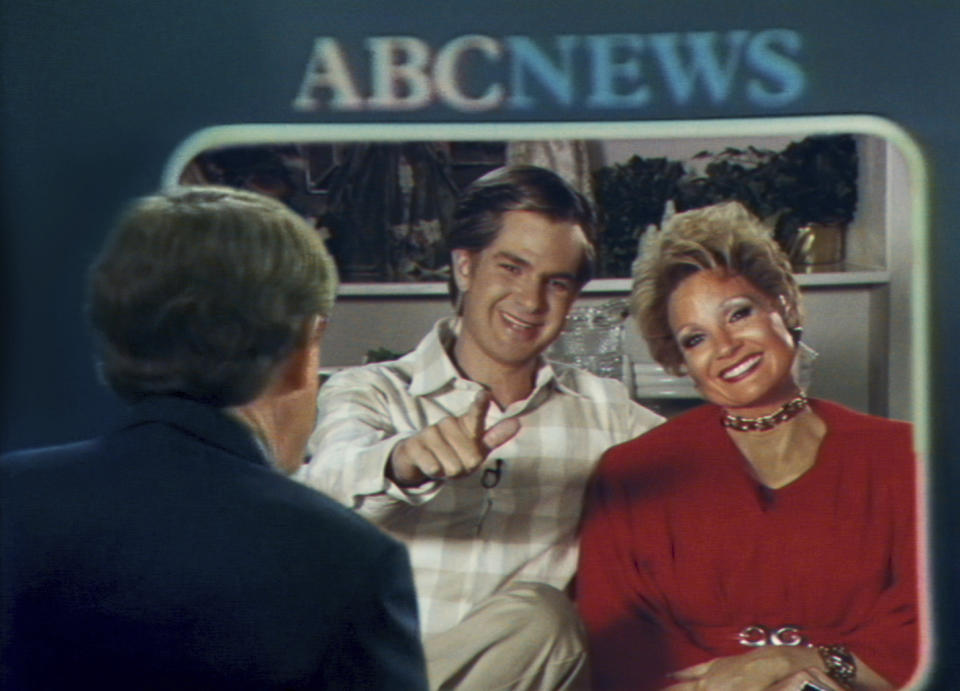 This image released by Searhlight Pictures shows Andrew Garfield as Jim Bakker, center, and Jessica Chastain as Tammy Faye Bakker in a scene from "The Eyes of Tammy Faye." (Searchlight Pictures via AP)