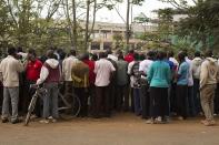 Onlookers stand along the road and look from a distance at Westgate Shopping Centre, where gunmen are holding hostages, in Nairobi September 22, 2013. Islamist militants were holed up with hostages on Sunday at the shopping mall in Nairobi, where at least 59 people have been killed in an attack by the al Shabaab group that opposes Kenya's participation in a peacekeeping mission in neighbouring Somalia. A volley of gunfire lasting about 30 seconds interrupted a stalemate of several hours, a Reuters witness said, speaking from near the Westgate shopping centre that has several Israeli-owned outlets and is frequented by expatriates and Kenyans. REUTERS/Siegfried Modola (KENYA - Tags: CIVIL UNREST)