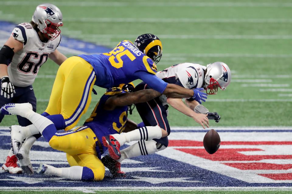 <p>Tom Brady #12 of the New England Patriots is sacked by Aaron Donald #99 and Ethan Westbrooks #95 of the Los Angeles Rams in the first half during Super Bowl LIII at Mercedes-Benz Stadium on February 3, 2019 in Atlanta, Georgia. (Photo by Elsa/Getty Images) </p>