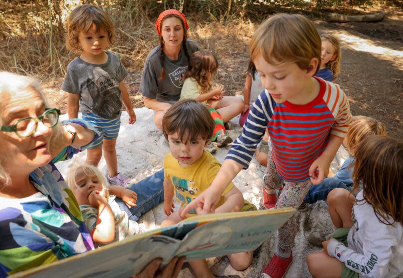 SOUTH PASADENA-CA-JULY 16, 2024: Fabienne Hadorn, co-founder of Arroyo Nature School, an outdoor-based program for preschool-aged kids, left, reads to the children in South Pasadena on July 16, 2024. (Christina House / Los Angeles Times)