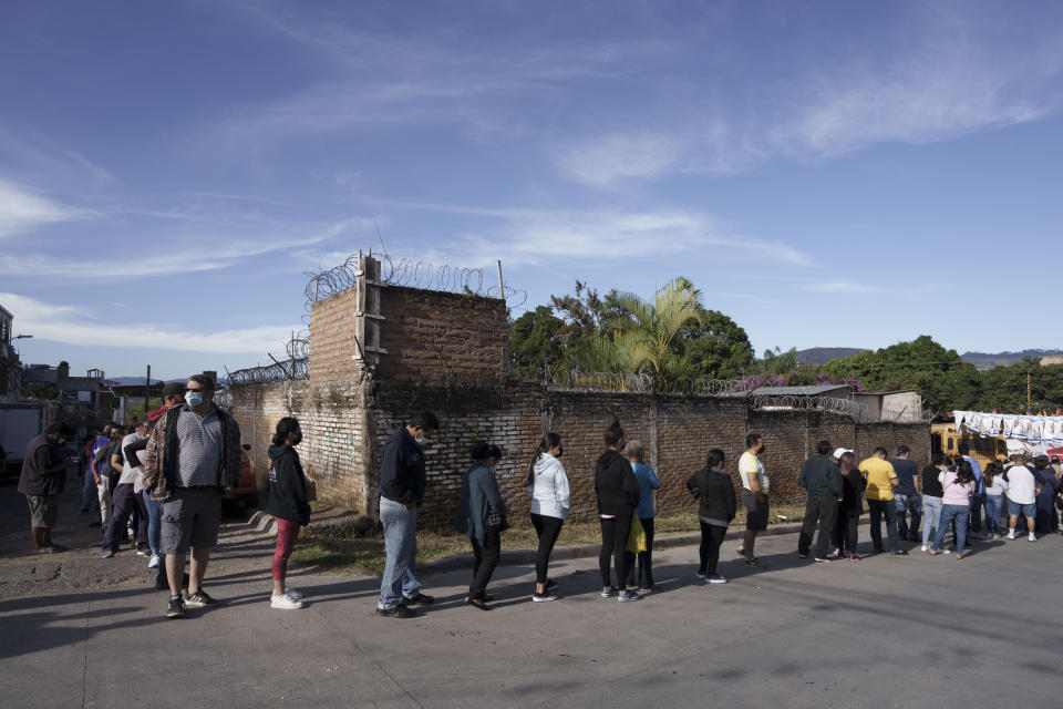 Voters line up outside a polling station during general elections in Tegucigalpa, Honduras, Sunday, Nov. 28, 2021. (AP Photo/Moises Castillo)