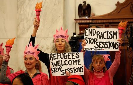 Protesters hold signs at the Senate Judiciary Committee confirmation hearing for U.S. Sen. Jeff Sessions (R-AL) to become U.S. attorney general on Capitol Hill in Washington, U.S. January 10, 2017. REUTERS/Kevin Lamarque