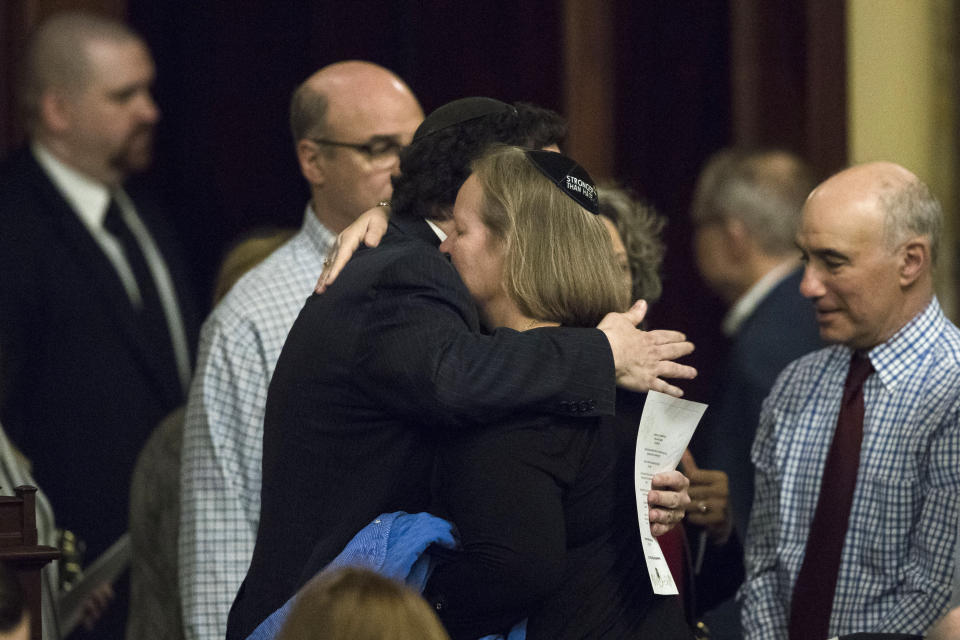 Dor Hadash Rabbi Cheryl Klein, center right, and New Light Rabbi Jonathan Perlman embrace after Pennsylvania lawmakers came together in an unusual joint session to commemorate the victims of the Pittsburgh synagogue attack that killed 11 people last year, Wednesday, April 10, 2019, at the state Capitol in Harrisburg, Pa. (AP Photo/Matt Rourke)